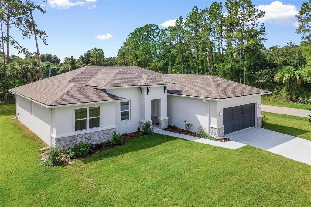 a aerial view of a house with a yard and large tree