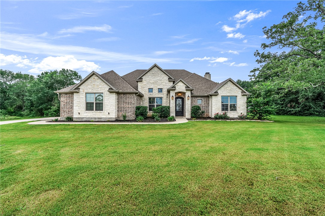 French country home featuring a front yard