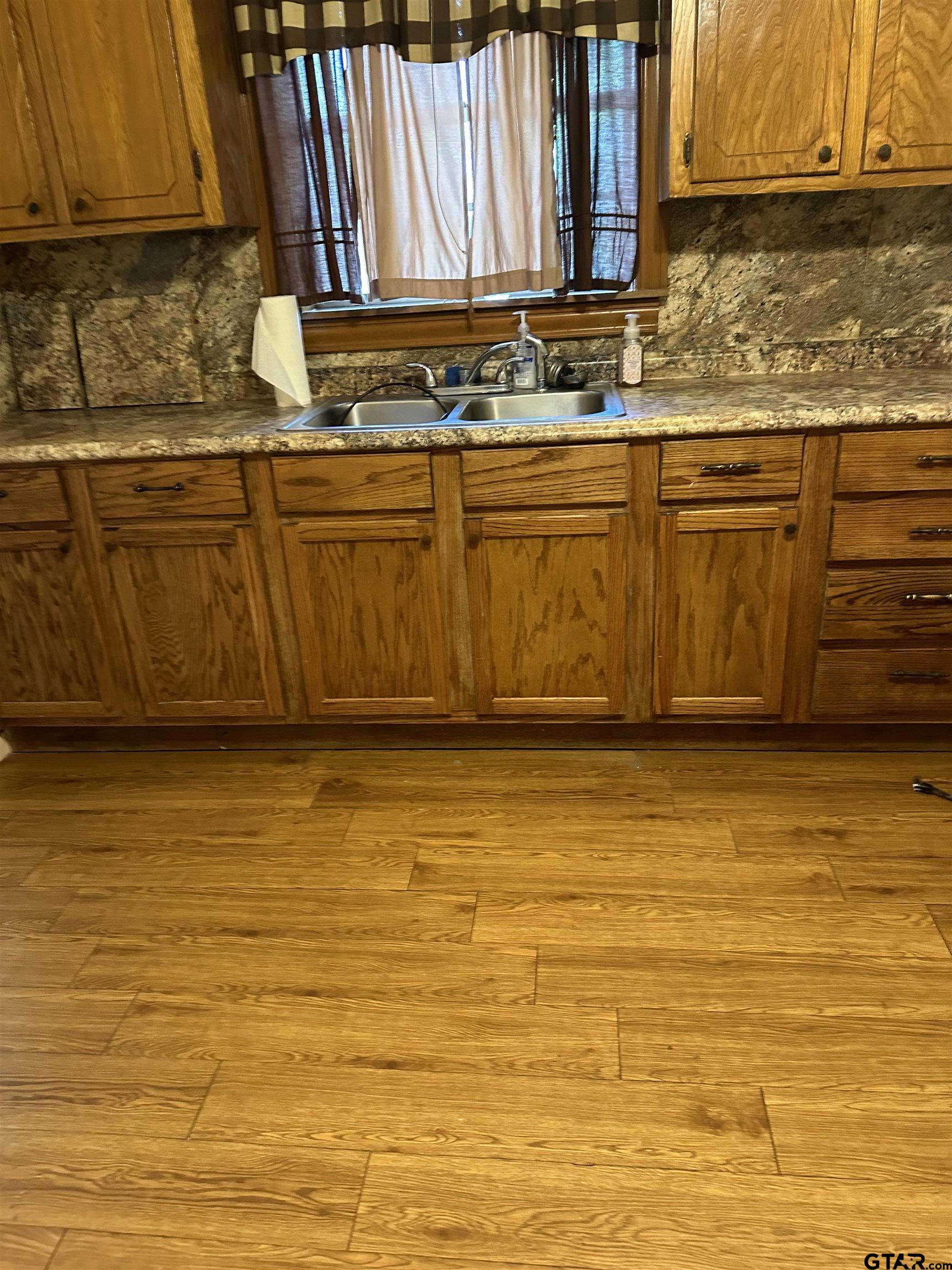 a view of a kitchen with stainless steel appliances granite countertop a sink and cabinets