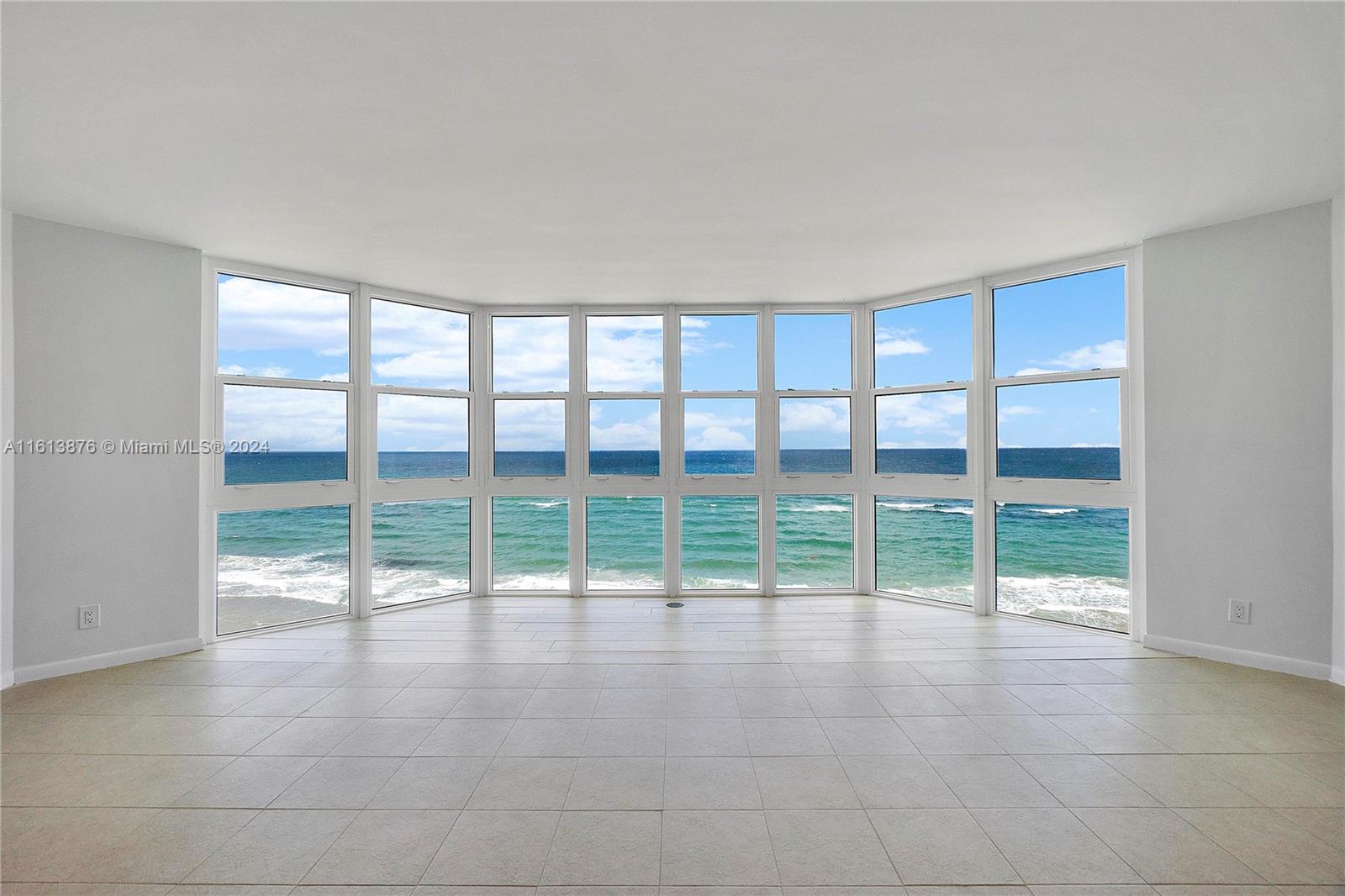 a view of an empty room with wooden floor and a floor to ceiling window