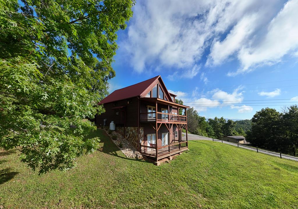 a view of a wooden house with a big yard and large trees