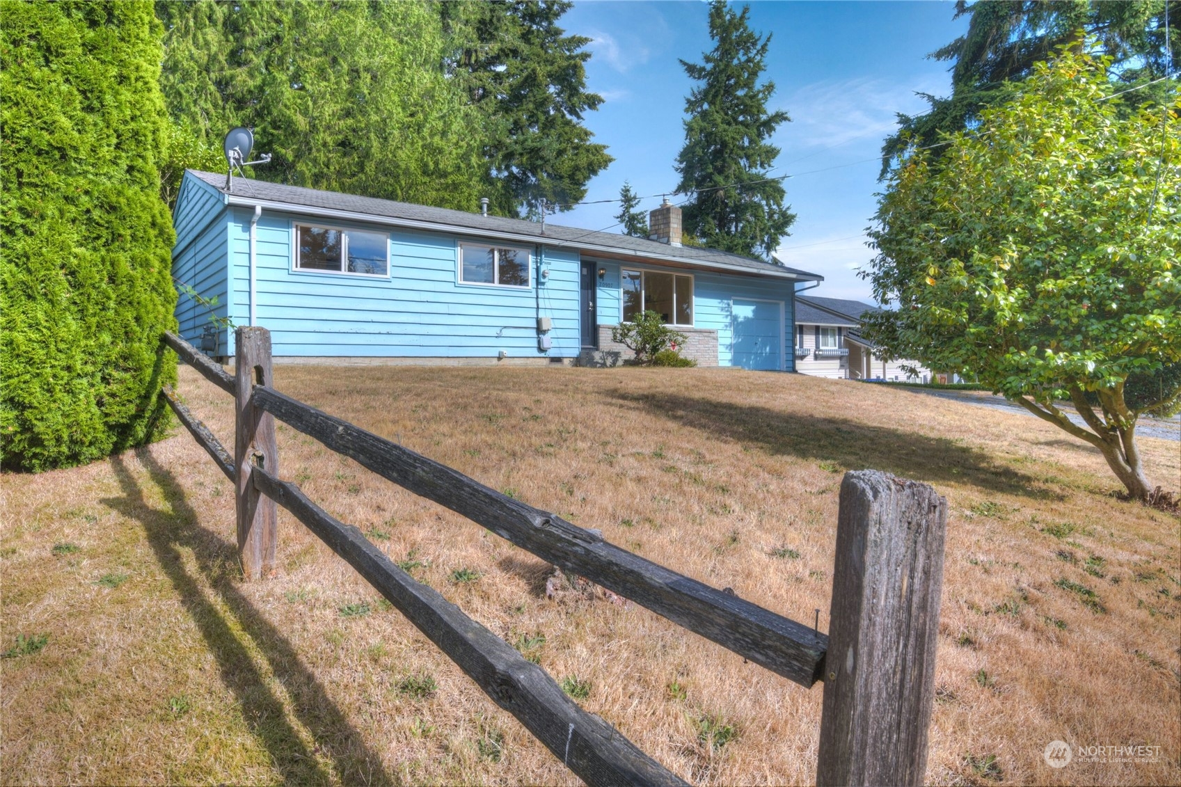 a view of a house with a yard and wooden fence