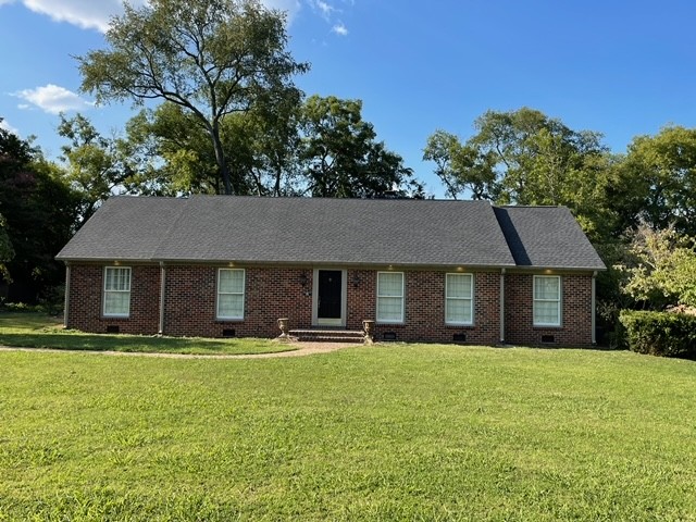 a front view of a house with a yard and trees