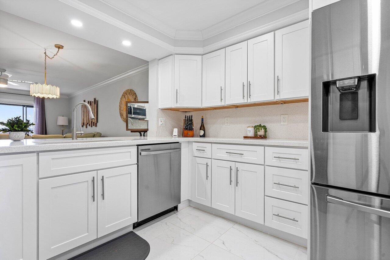 a kitchen with white cabinets and refrigerator