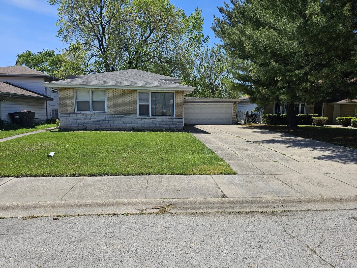 a front view of a house with a garden and yard