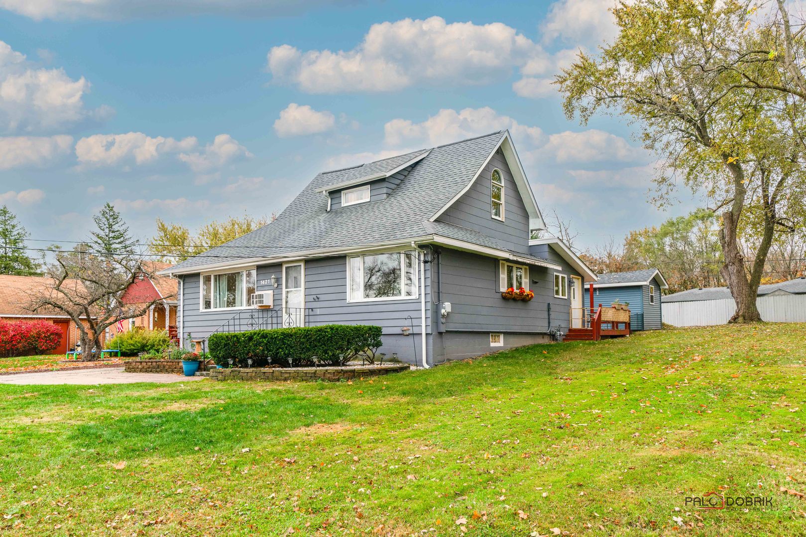 a front view of a house with a yard and trees