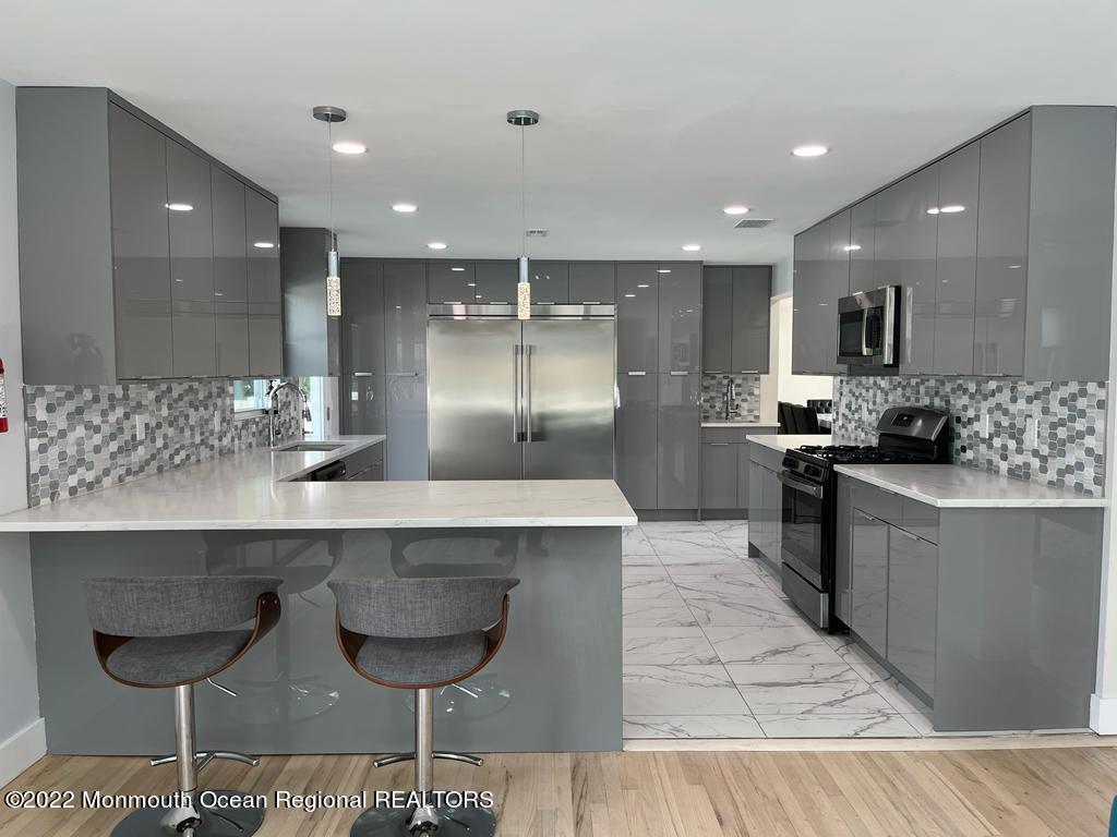 a kitchen with kitchen island granite countertop a counter top space appliances and a sink