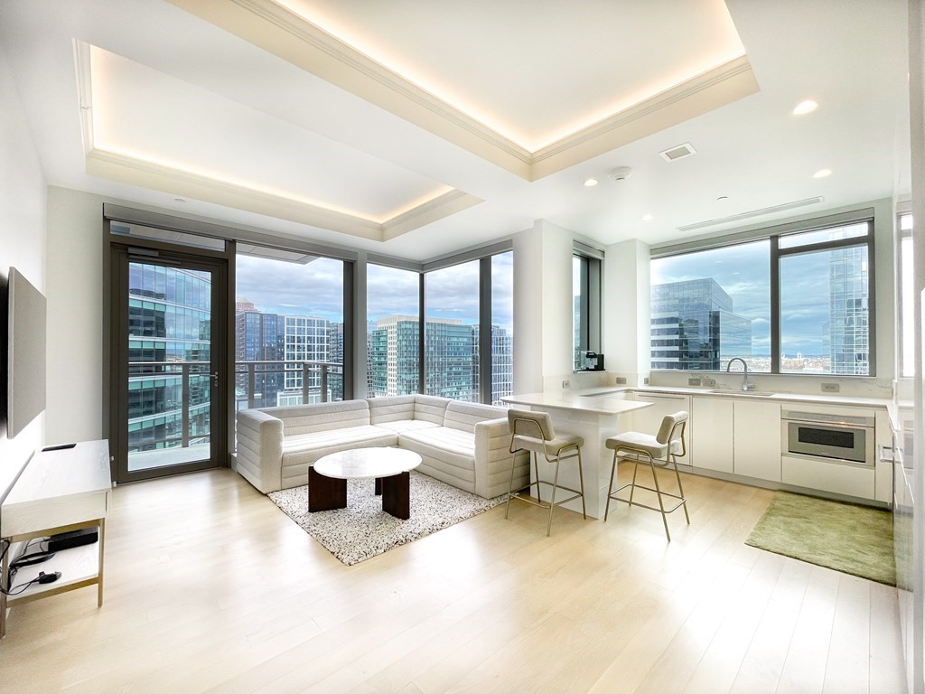 a living room with furniture and floor to ceiling windows