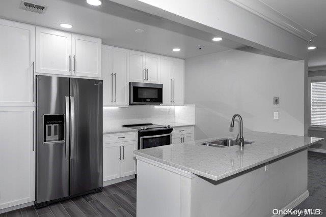 a kitchen with a sink a refrigerator a microwave and cabinets