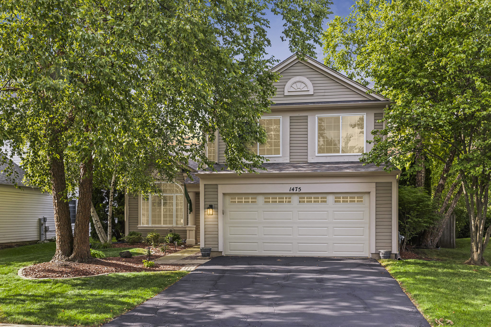 a front view of a house with a yard and garage