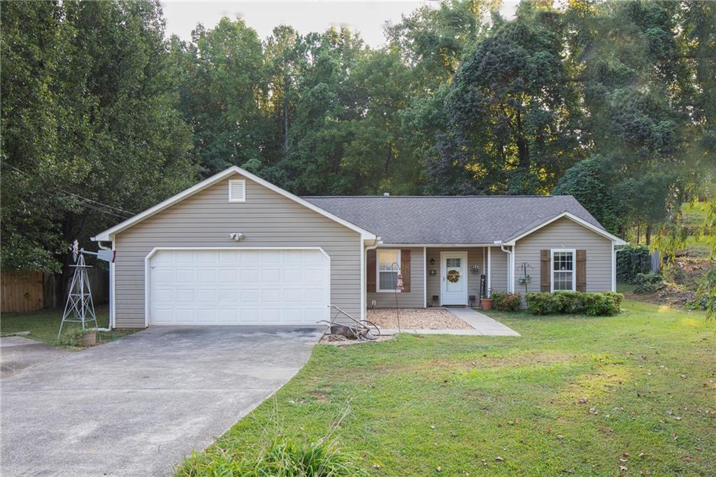 a view of a house with yard and large tree