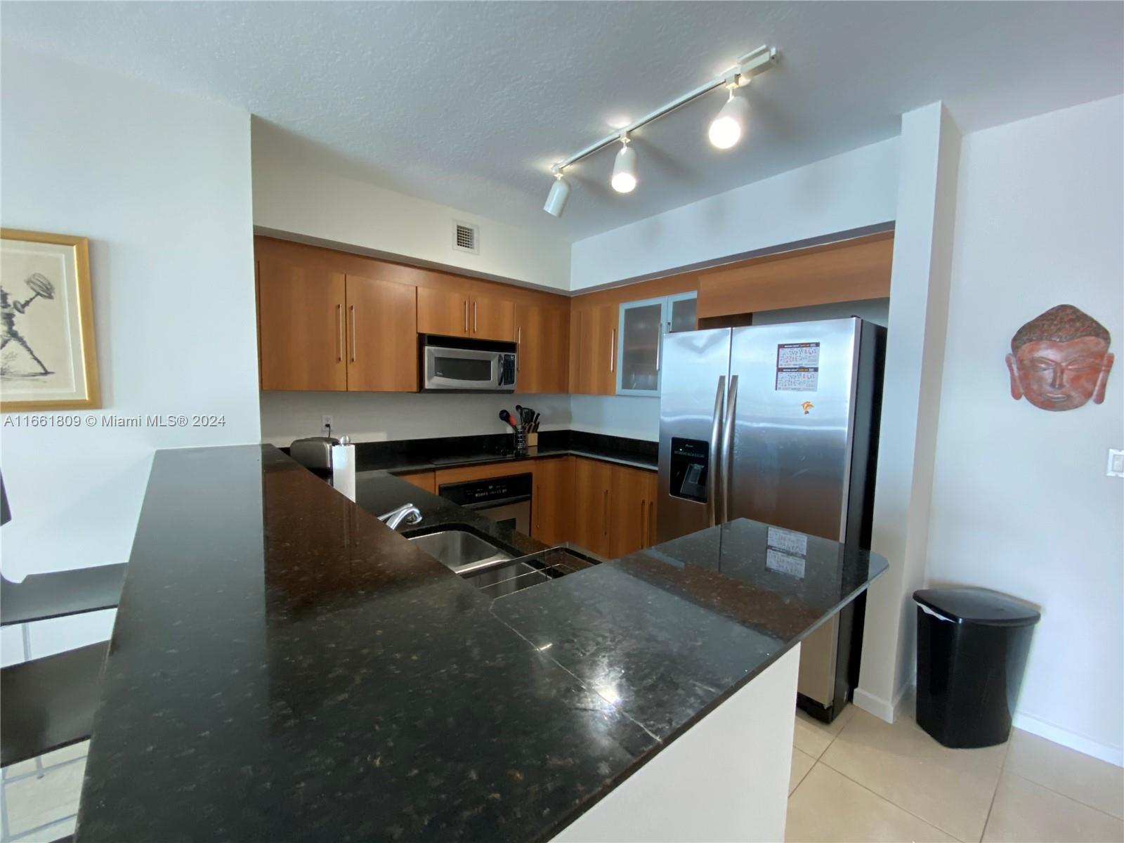 a kitchen with stainless steel appliances granite countertop a sink a stove and a refrigerator