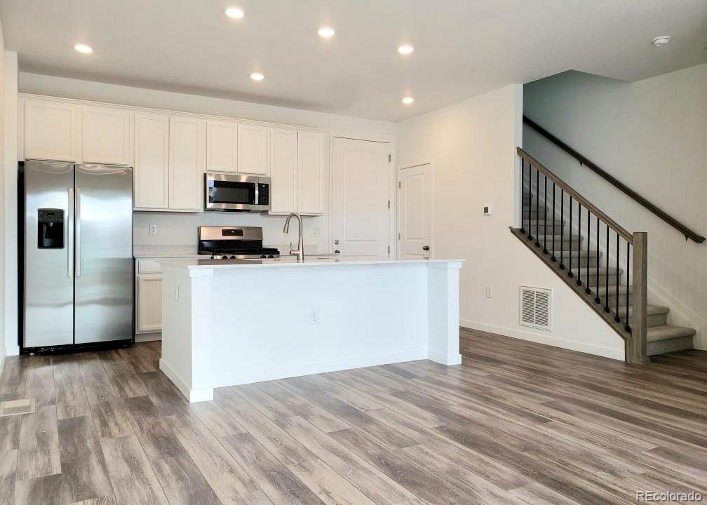 a kitchen with stainless steel appliances a refrigerator and a stove top oven