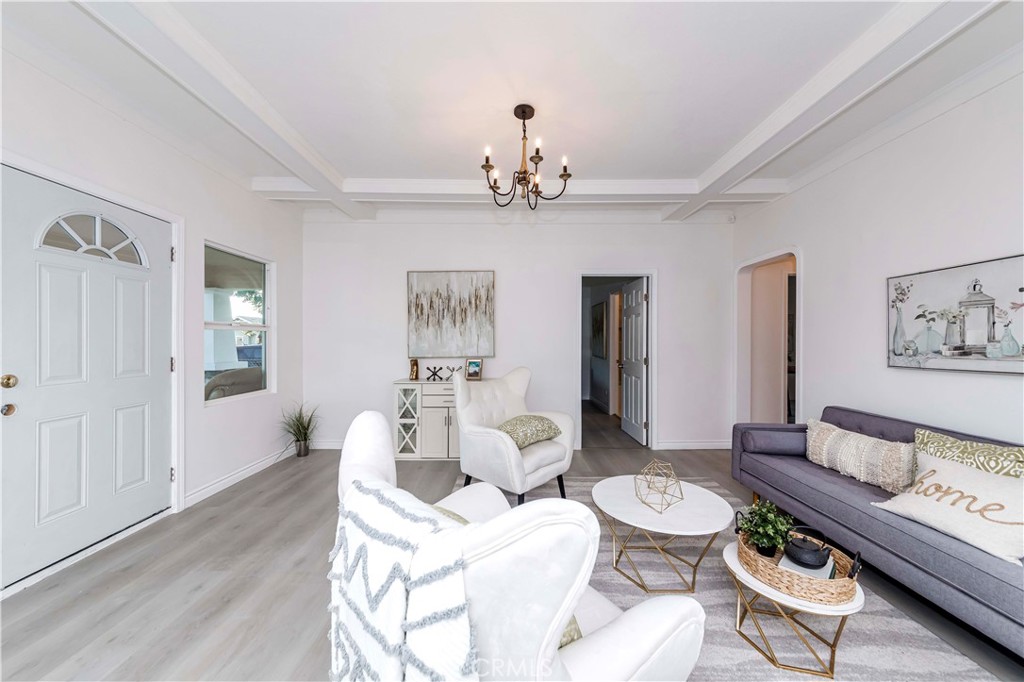 a living room with furniture a chandelier and a rug