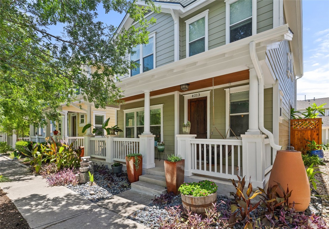 a front view of a house with a chairs and potted plants