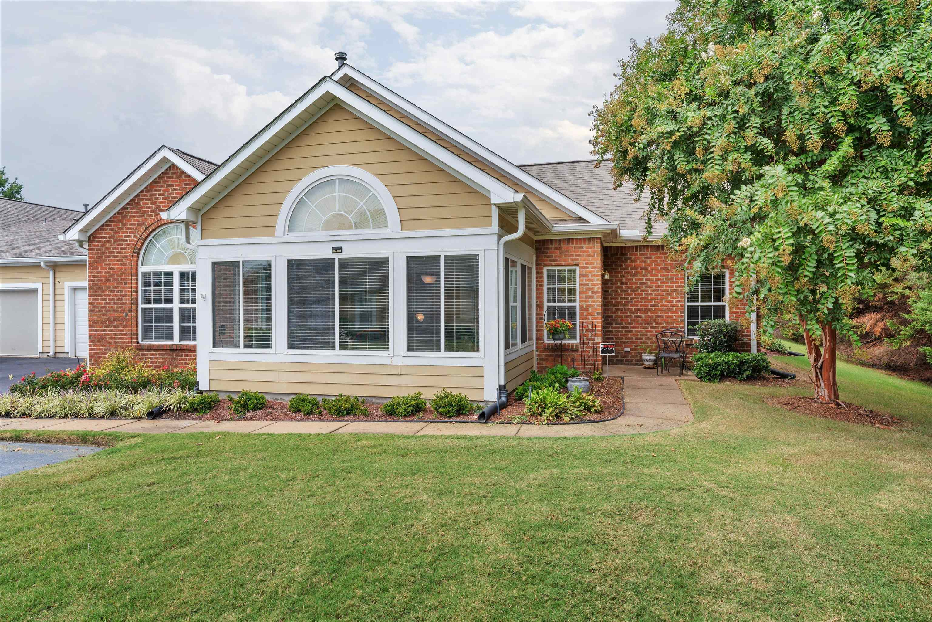 a front view of a house with a garden and plants