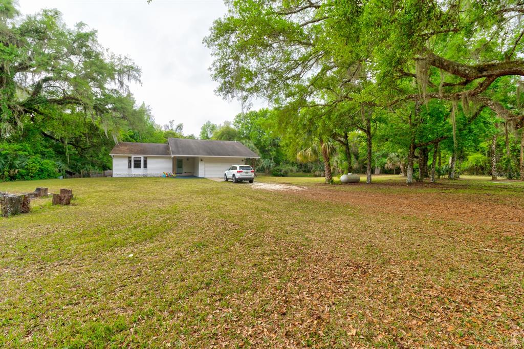 a view of a house with a yard and sitting area