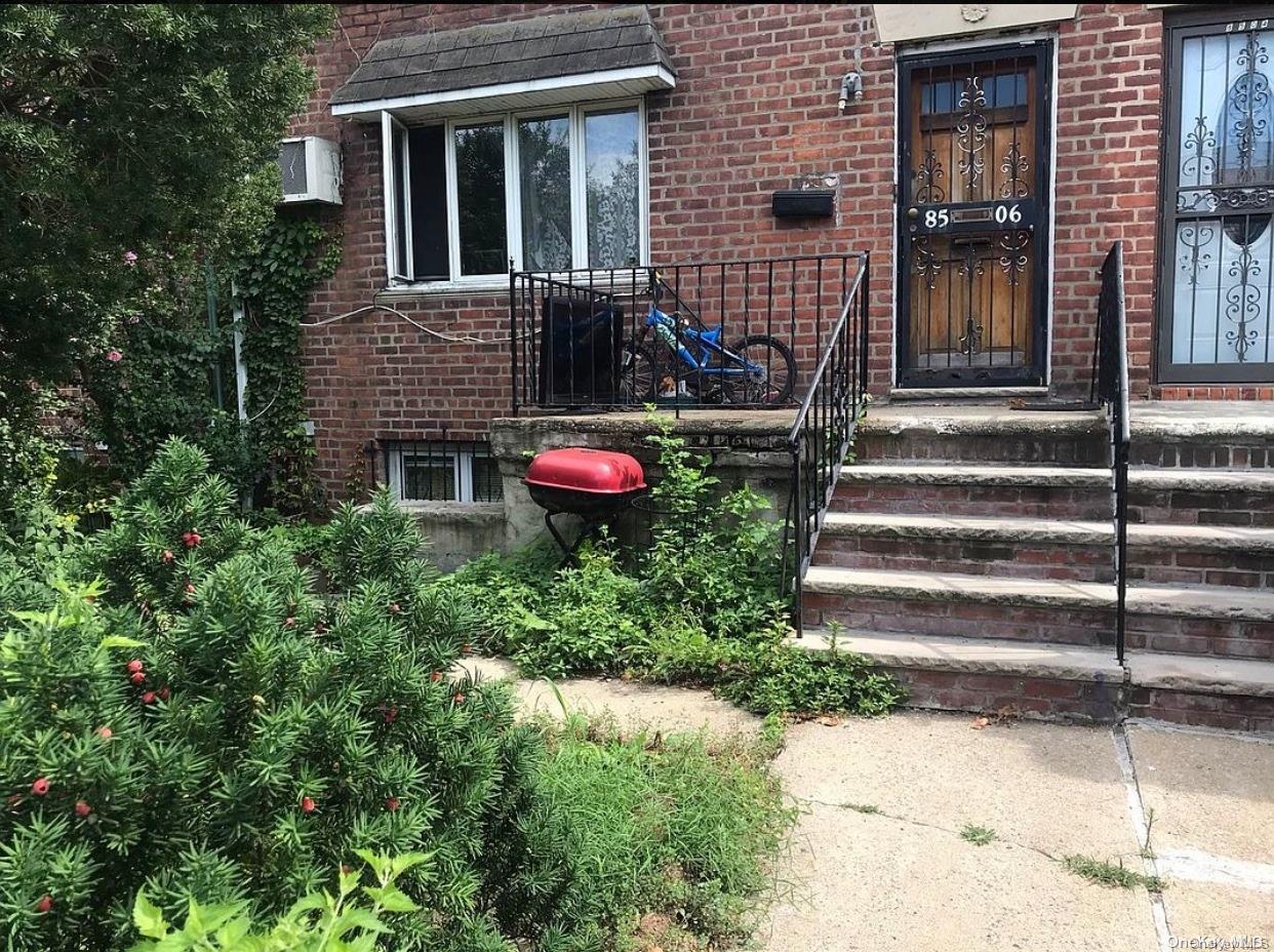 a view of a house with potted plants and a table and chair