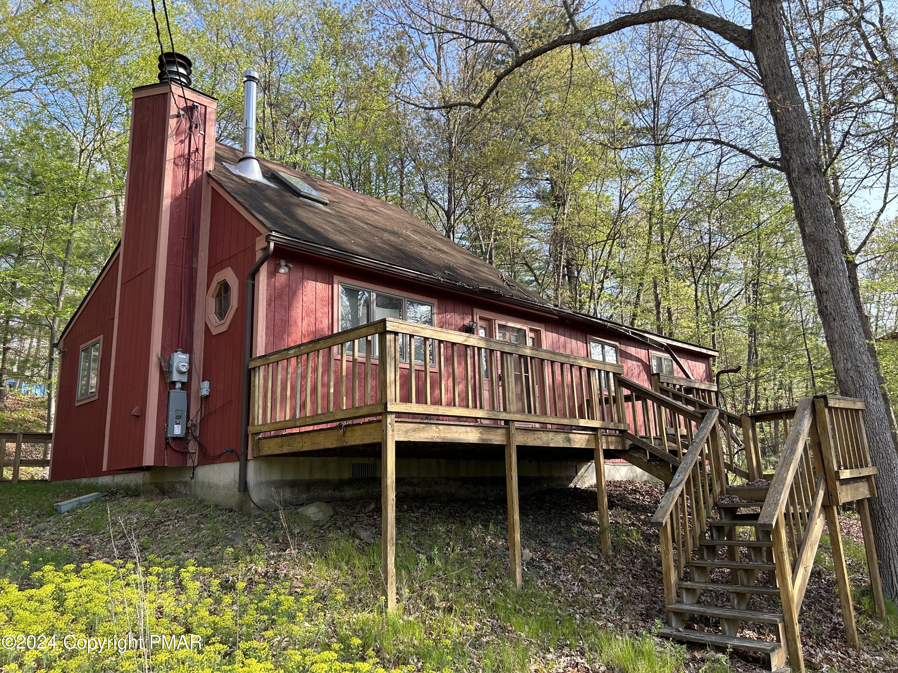 a view of a backyard with a large tree and a deck