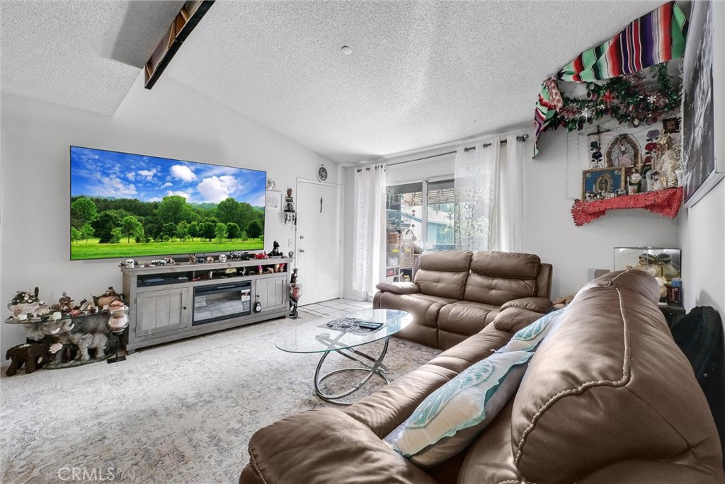 a living room with furniture a flat screen tv and a floor to ceiling window