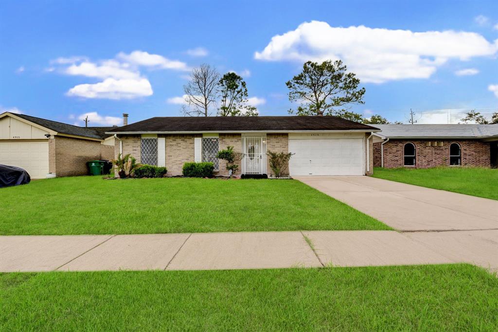 a front view of a house with a garden and yard