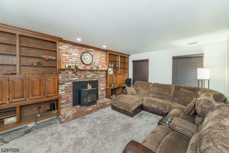 a living room with furniture a fireplace and a walk in closet