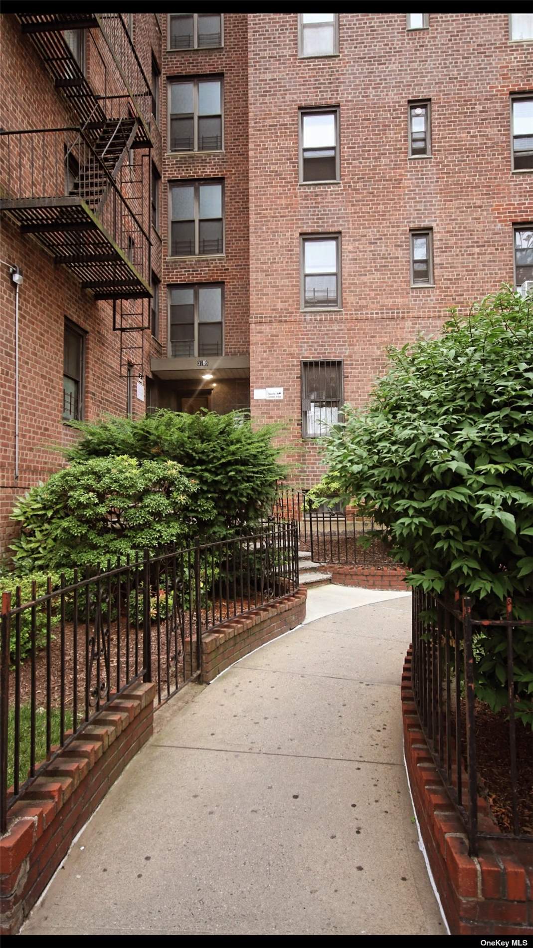 a pathway of a brick house with wooden fence