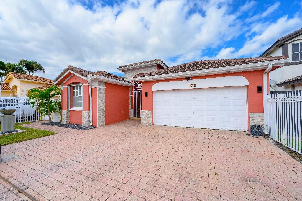 a view of house with yard and garage