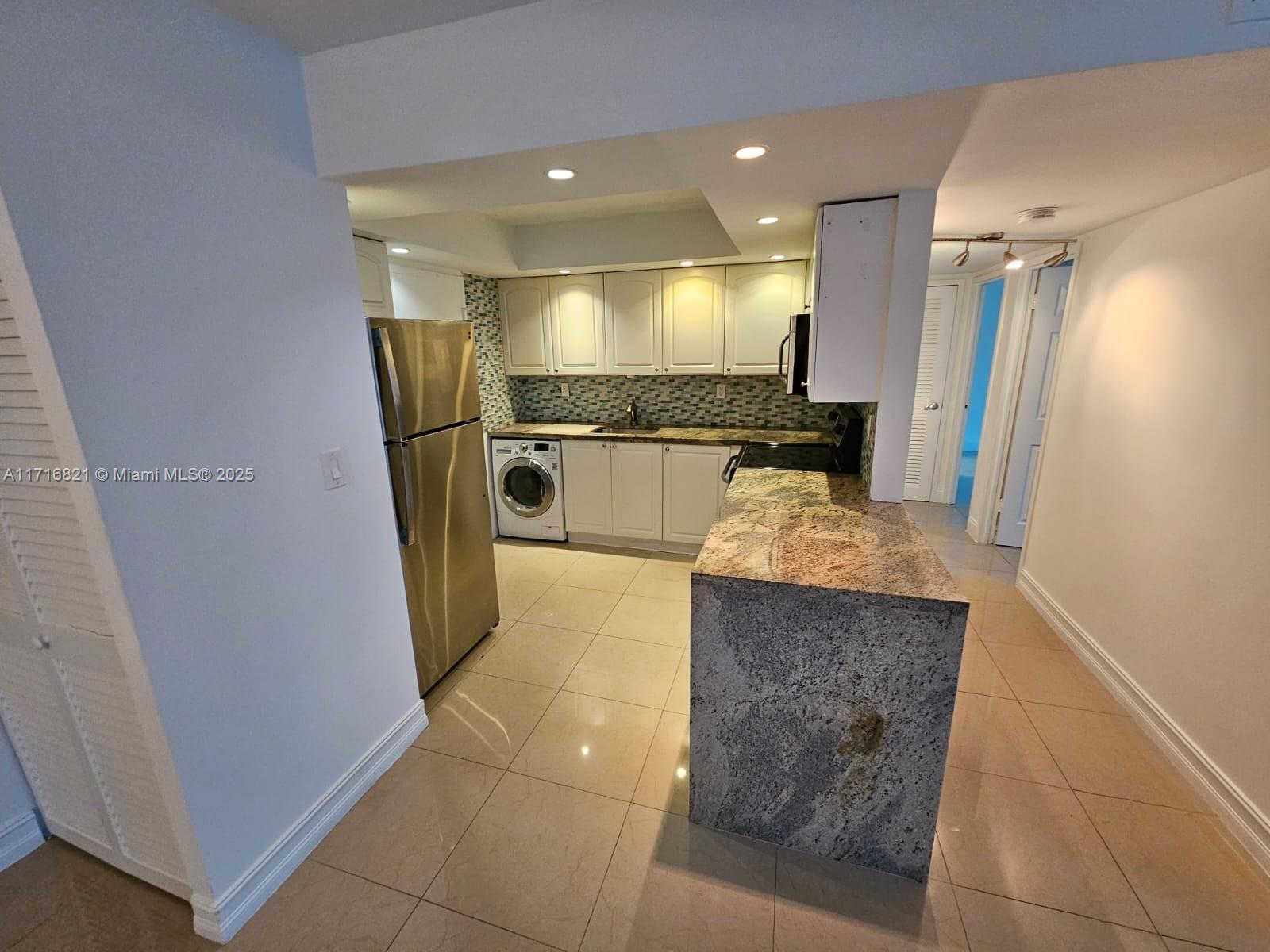 a kitchen with stainless steel appliances granite countertop a refrigerator and a stove