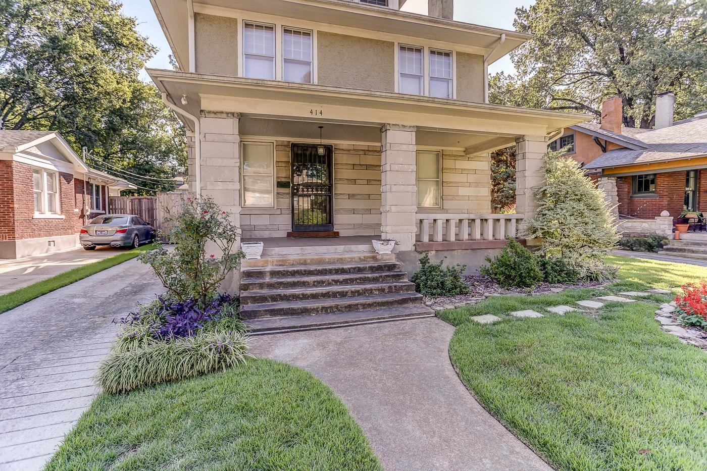 a front view of a house with a yard and outdoor seating