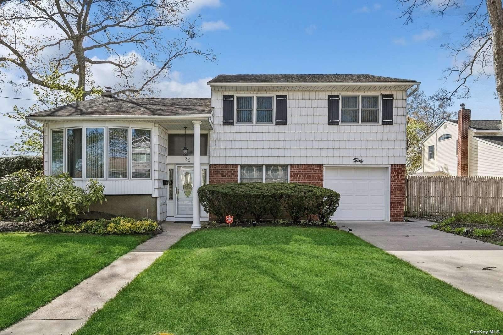 a front view of a house with a yard and potted plants