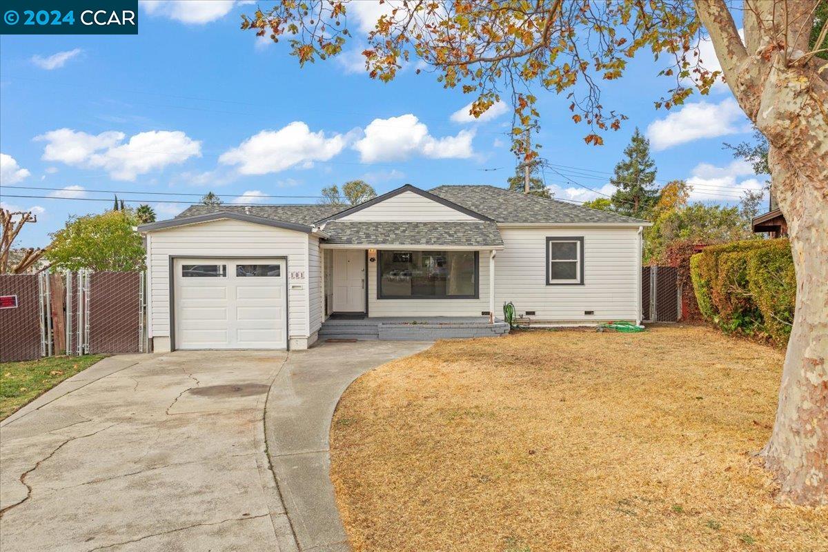 a front view of a house with yard and parking