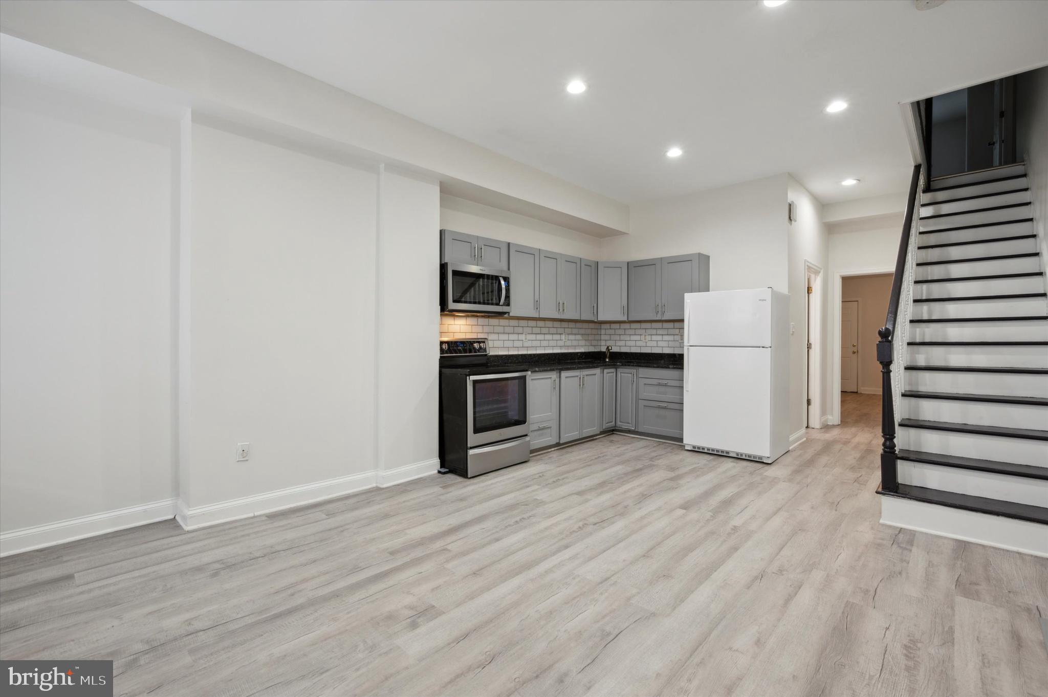 a view of kitchen with wooden floor and electronic appliances