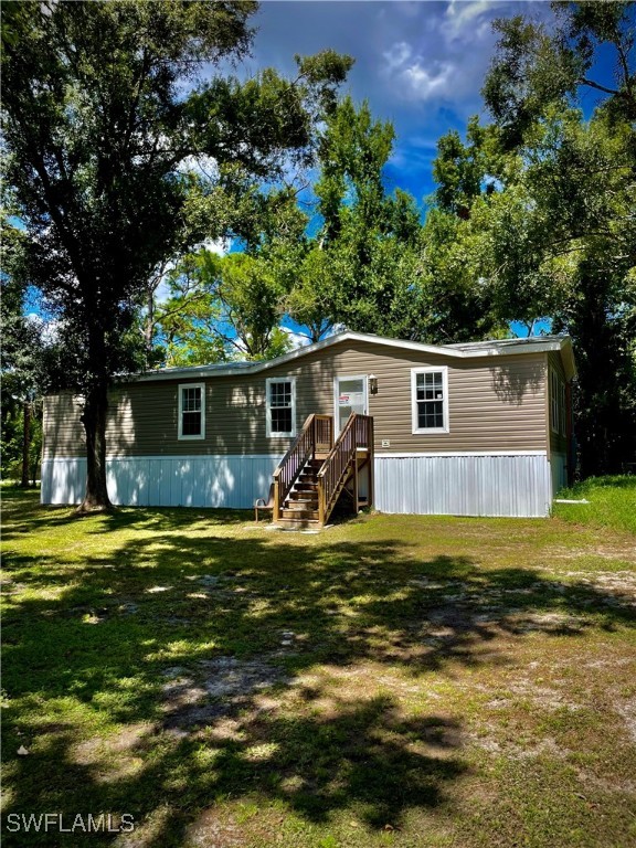 a view of a house with a big yard and a large tree