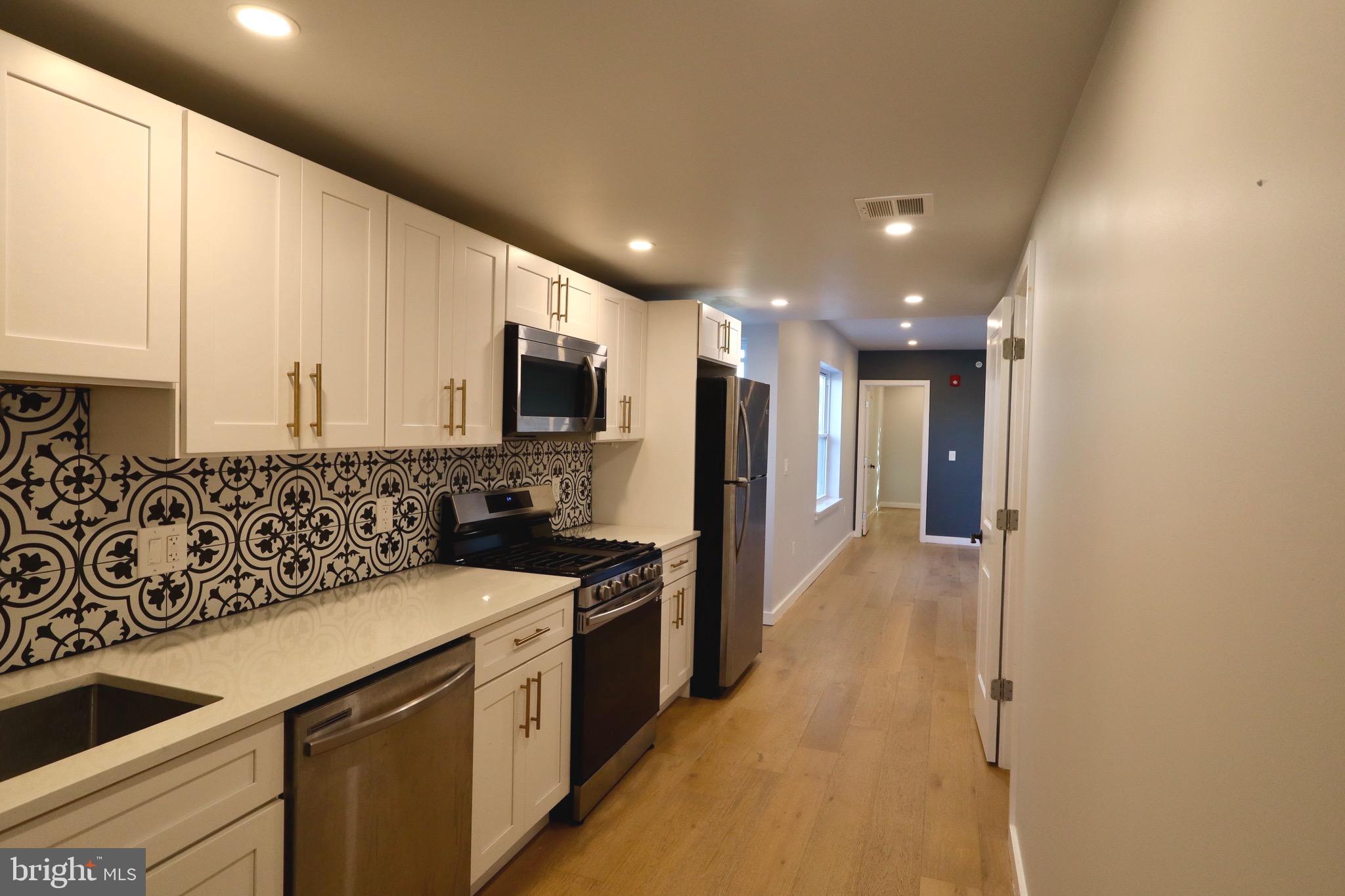 a kitchen with stainless steel appliances a sink stove and refrigerator