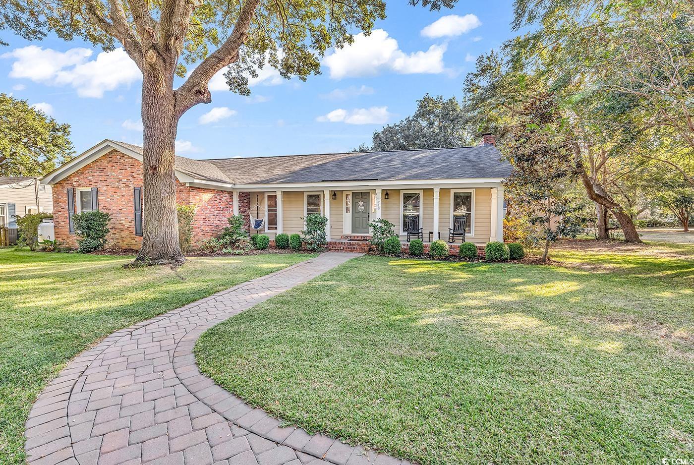 Single story brick home featuring a porch and a fr