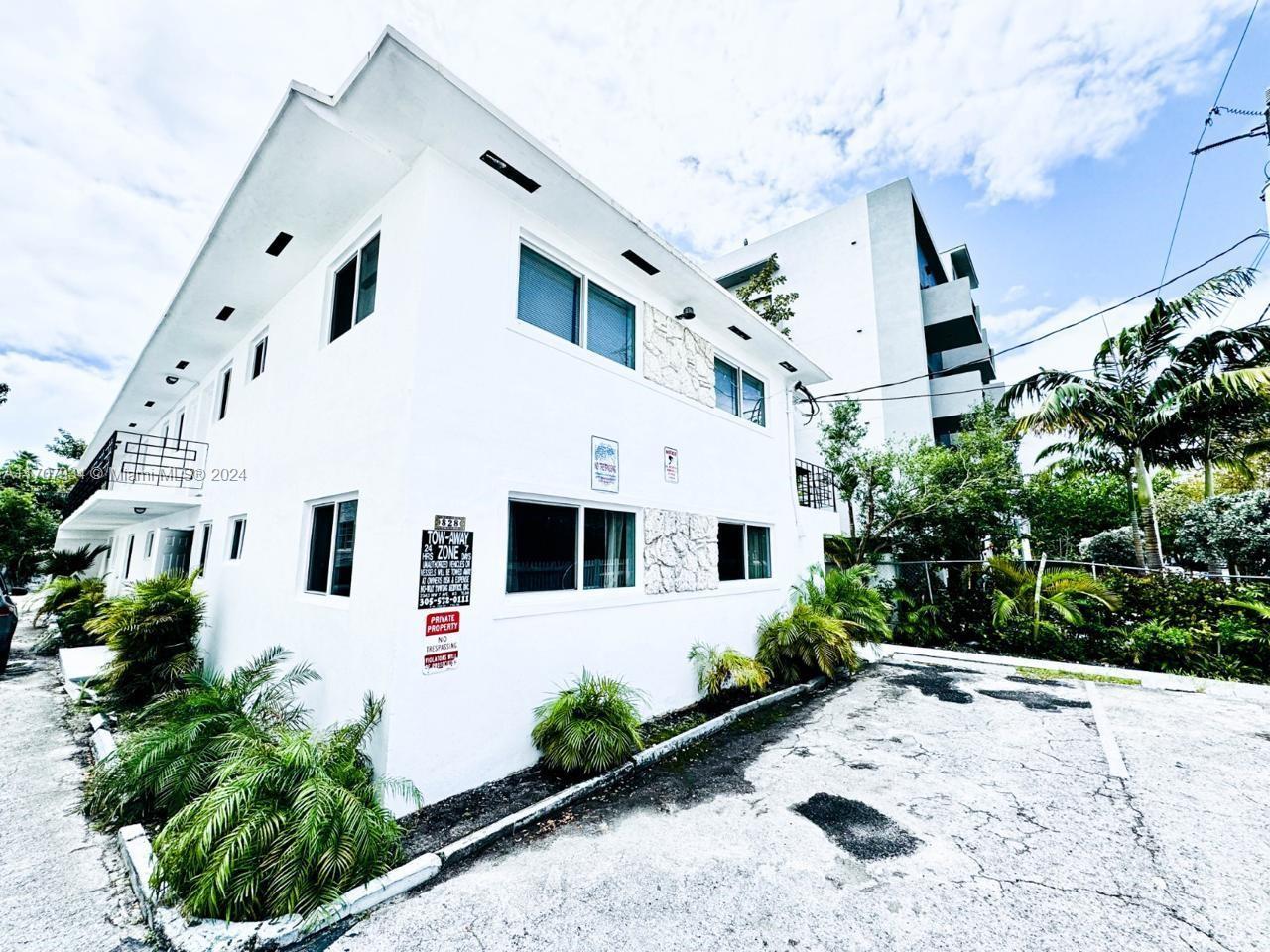 a large white building with garden in front of it