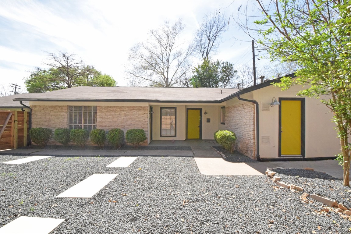 a front view of a house with a yard and potted plants