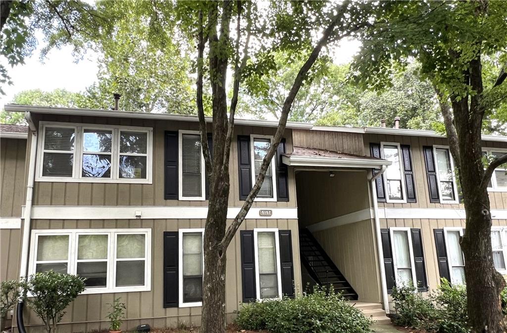 a front view of a house with a tree