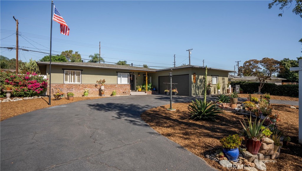 a front view of a house with a yard and potted plants