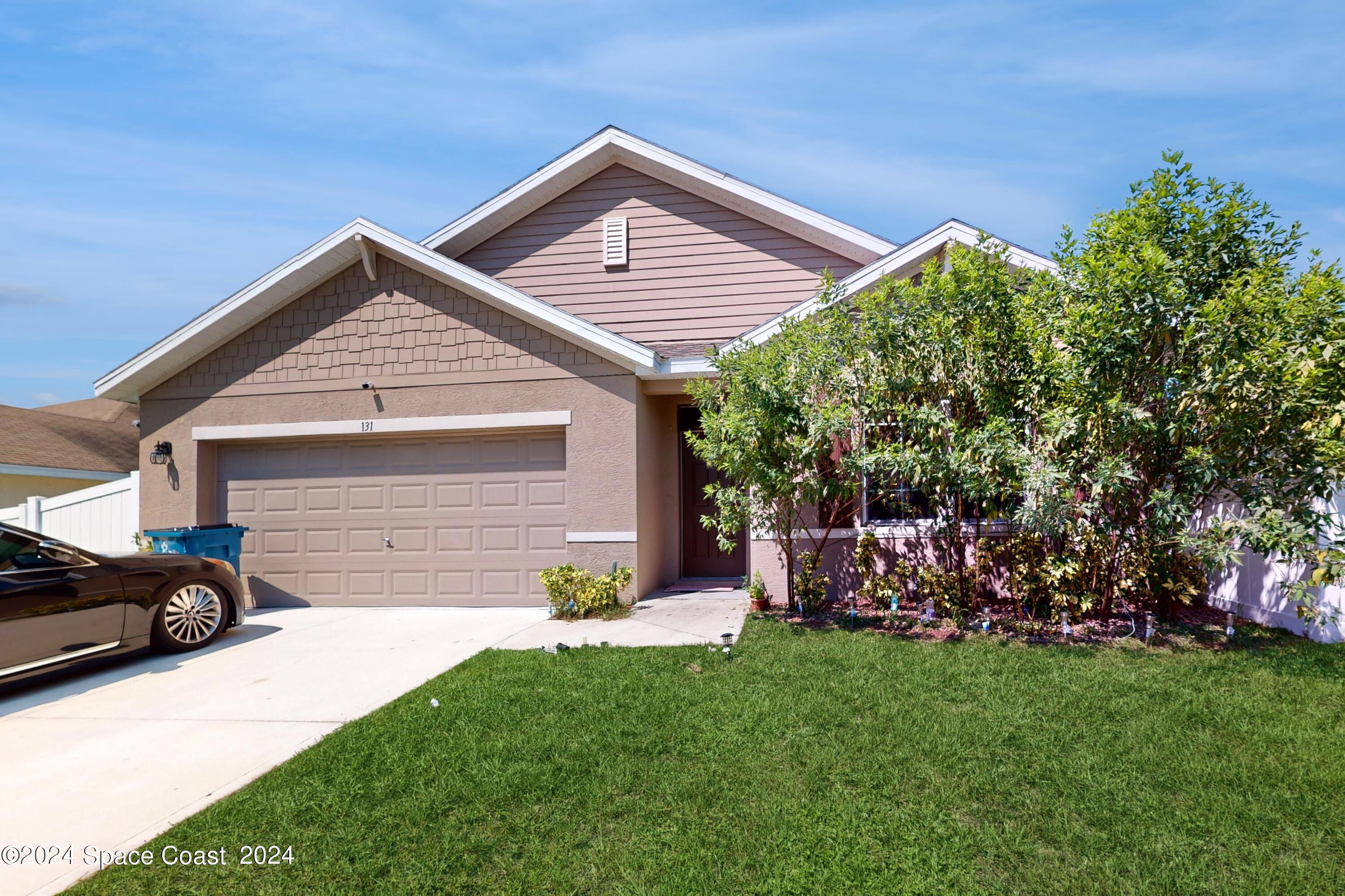 a front view of a house with a garden and yard