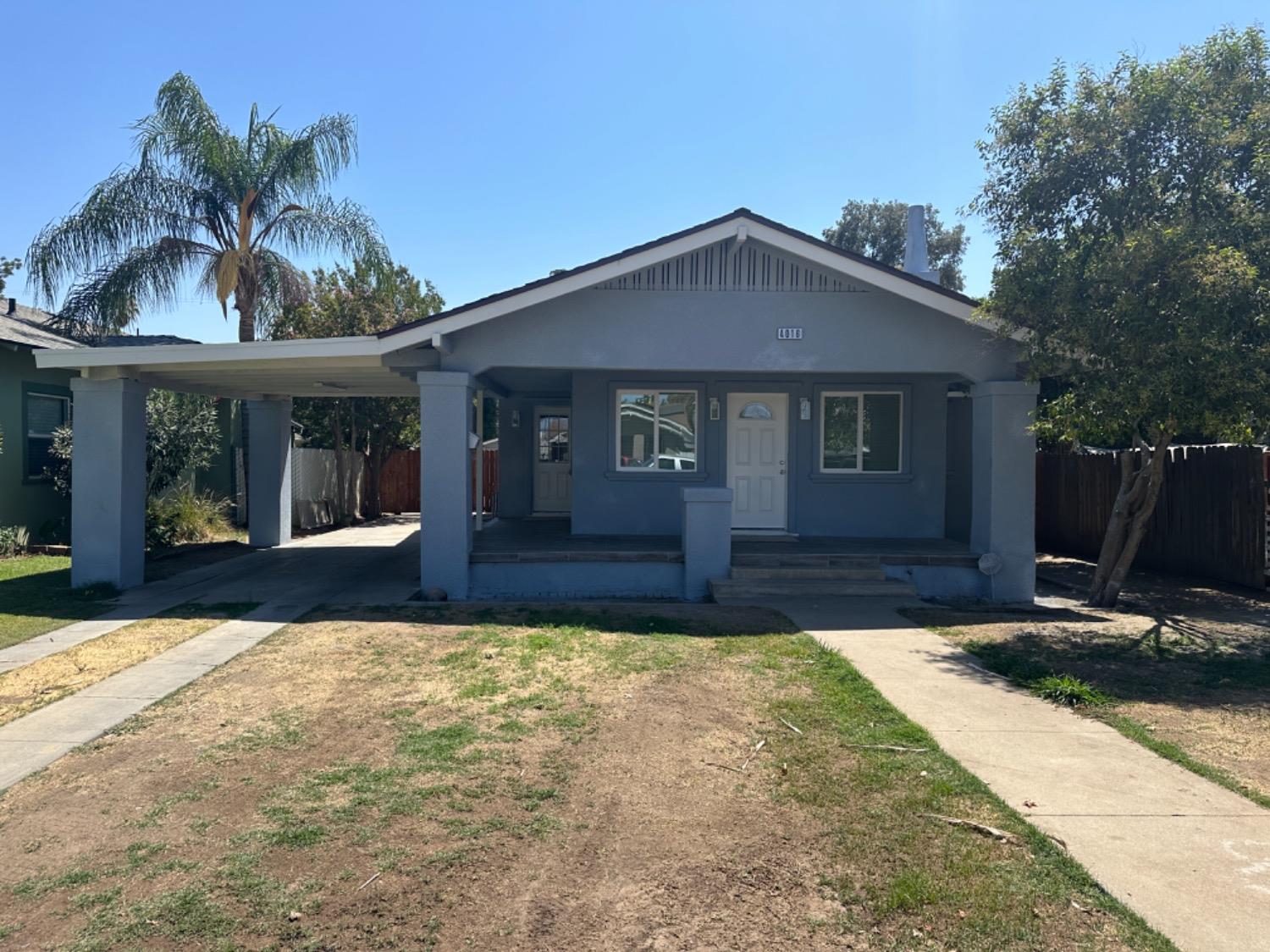 a front view of house with yard and trees in the background