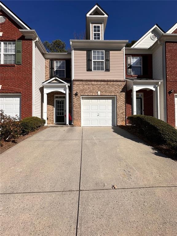 a front view of a house with yard and parking space