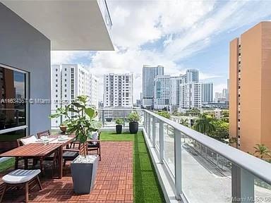 a balcony with wooden floor table and chairs