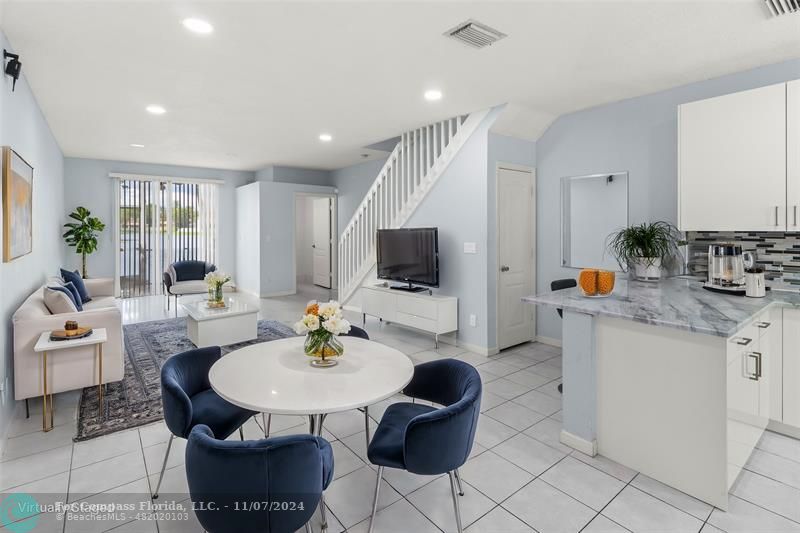 a living room with kitchen island furniture and a flat screen tv