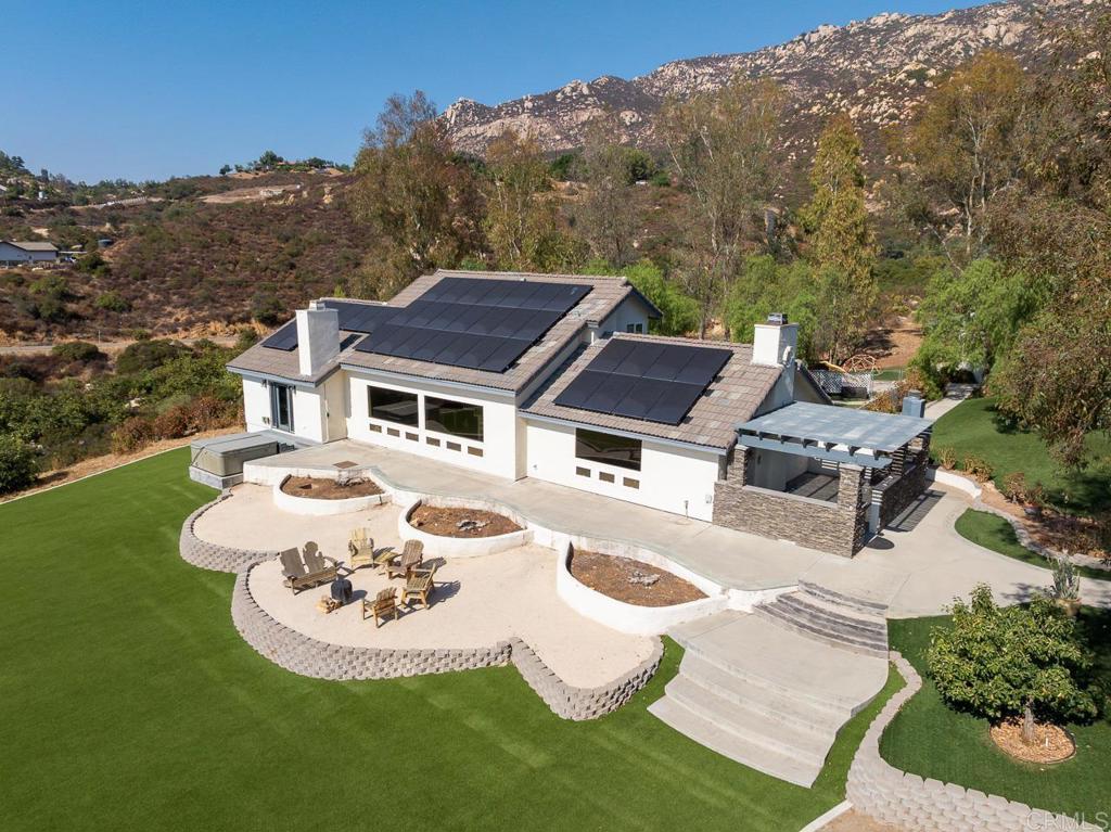 a view of a white house with a big yard