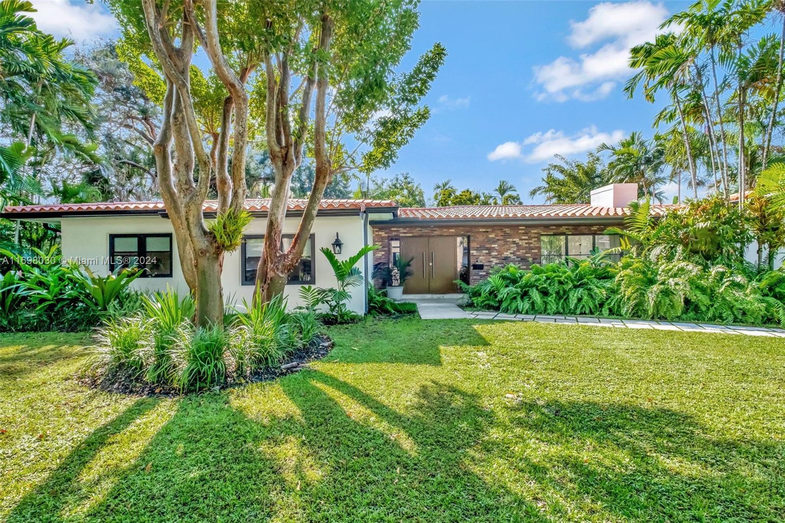 a view of a house with a yard and potted plants