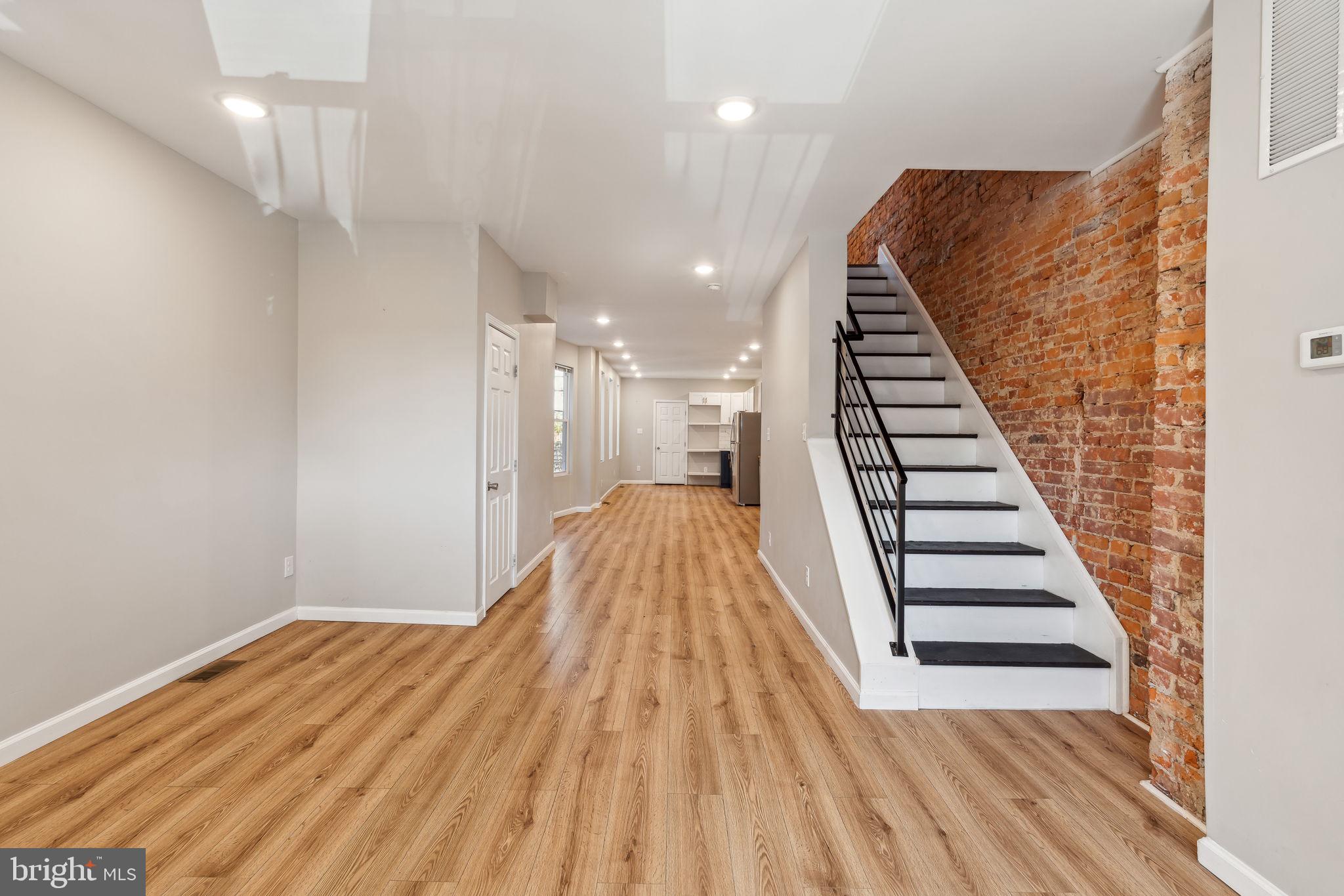 a view of a hallway with wooden floor and staircase