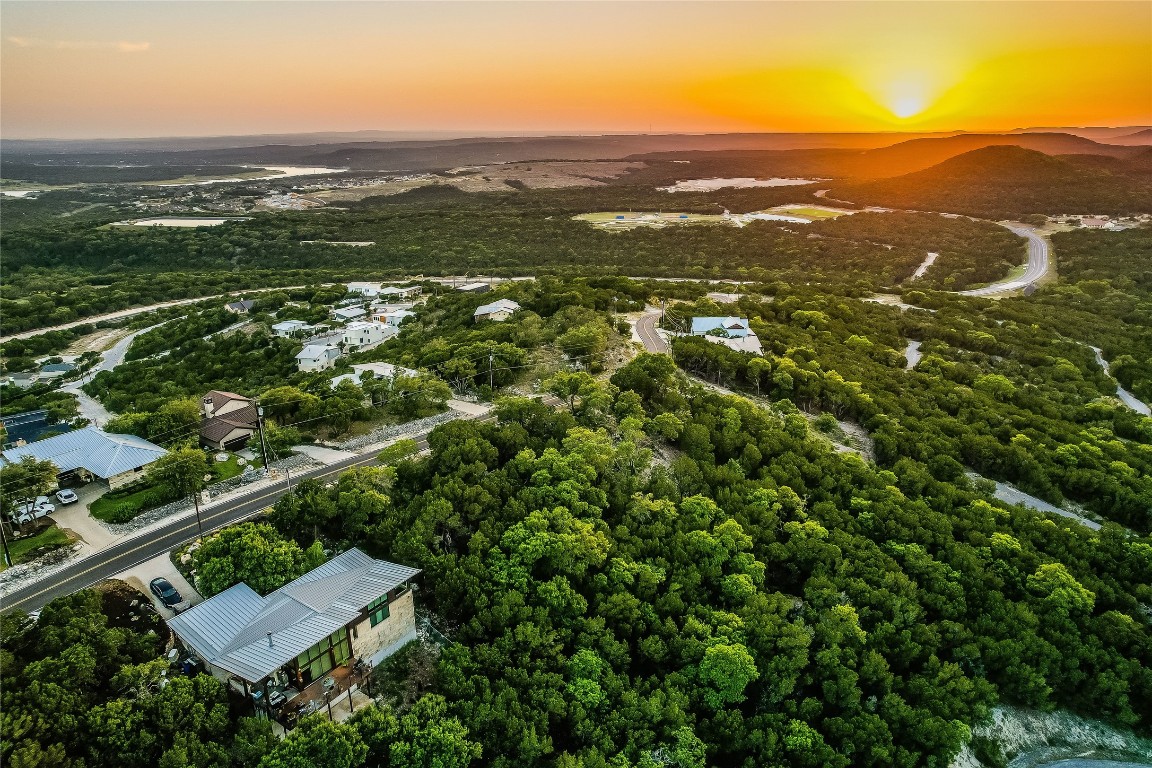 an aerial view of residential house with parking and trees