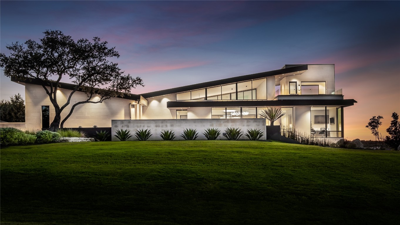 a view of a big house with a big yard and large trees